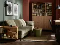 Jak urzadzic pokoj goscinny: przytulna zielona sofa, drewniana biblioteczka i stylowe dodatki tworzą idealne miejsce dla gości.