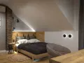 Przytulny pokój na poddaszu z drewnianym łóżkiem i ceglaną ścianą. Inspiracje dla miłośników loftowego stylu.