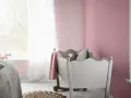 Pokój dziecięcy z łóżeczkiem i kocykiem w odcieniu amarant kolor.