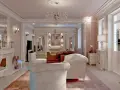 Elegancki salon w stylu francuskim z kryształowymi żyrandolami, kominkiem i wygodnymi sofami.