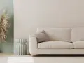 Jasna sofa i dekoracje z traw pampasowych to świetny pomysł na pustą ścianę w salonie.