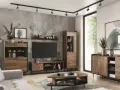 Salon w stylu retro inspiracje: drewniane meble, tapeta z liśćmi, szara sofa i nowoczesne oświetlenie tworzą przytulną przestrzeń.