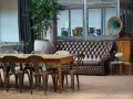 Stary gramofon i pikowana kanapa w salonie. Inspiracja, co zrobić ze starymi meblami, by nadać im nowy charakter.
