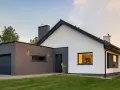 Nowoczesny dom z garażem, biały tynk i grafitowe detale. Tynk mozaikowy inspiracje dla Twojego domu.