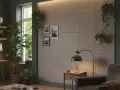 Nowoczesny salon z betonową ścianą, wiszącymi roślinami i wygodnym fotelem.