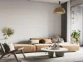 Wabi-sabi wnętrza: beżowa kanapa, pleciony fotel, suszone trawy i palma tworzą przytulną, naturalną przestrzeń.
