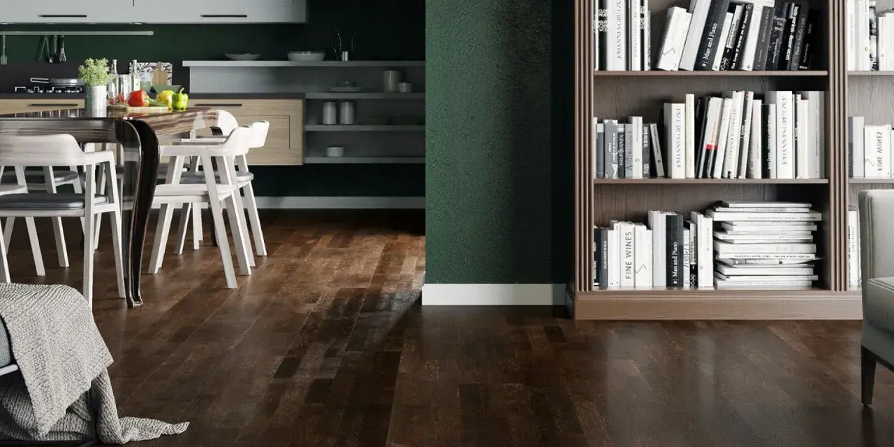 Nowoczesny salon z ciemną podłogą, kuchnią i regałem pełnym książek.