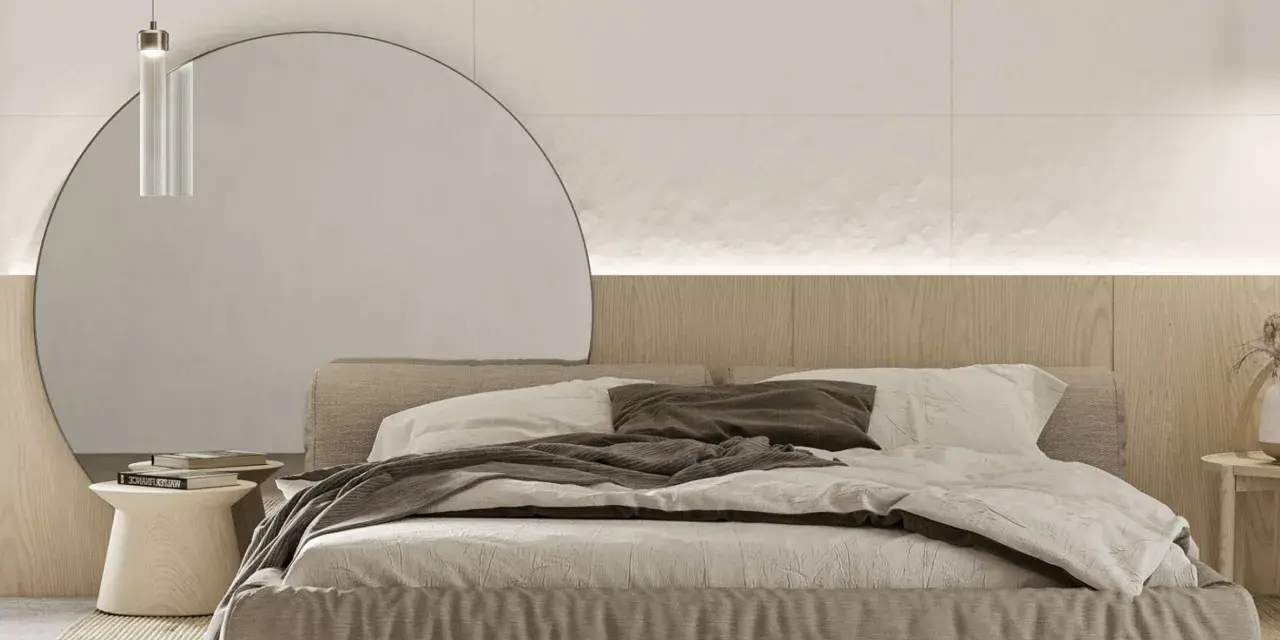 Przytulna sypialnia inspiracje: minimalistyczne łóżko z lnianą pościelą, okrągłe lustro i drewniana ściana tworzą spokojną atmosferę.