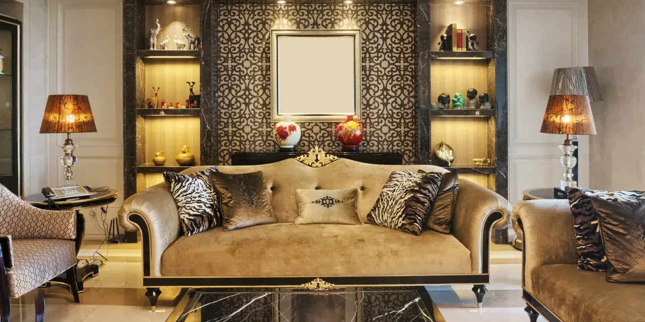 Elegancki salon w stylu art deco z beżową kanapą, ozdobnymi poduszkami i marmurowym stolikiem.