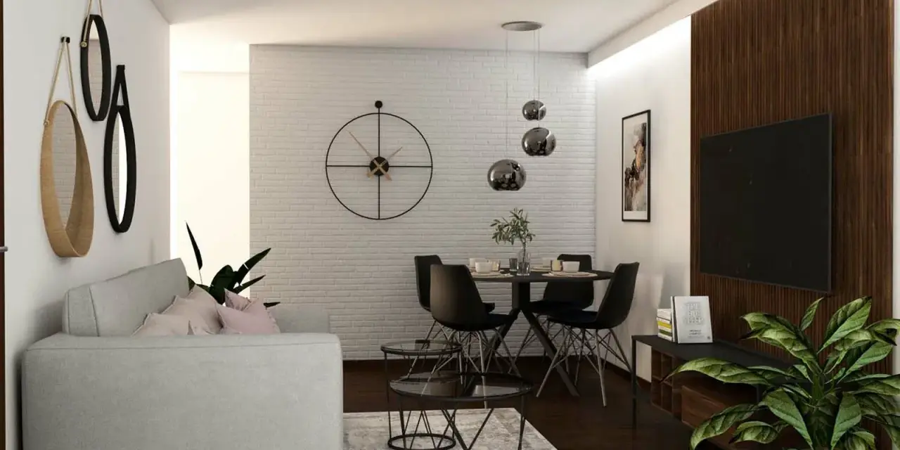 Nowoczesny salon z szarą kanapą, okrągłym stołem i czarnymi krzesłami. W tle biała ceglana ściana z dużym zegarem. Ciemna, brązowa podłoga w salonie dodaje elegancji.