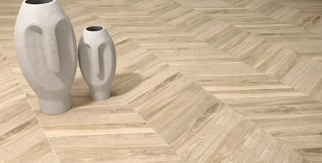 Jasne, oto propozycja:

Drewnopodobne **płytki w jodełkę na podłogę** tworzą elegancki wzór, na którym stoją dwie nowoczesne wazy w kształcie twarzy.