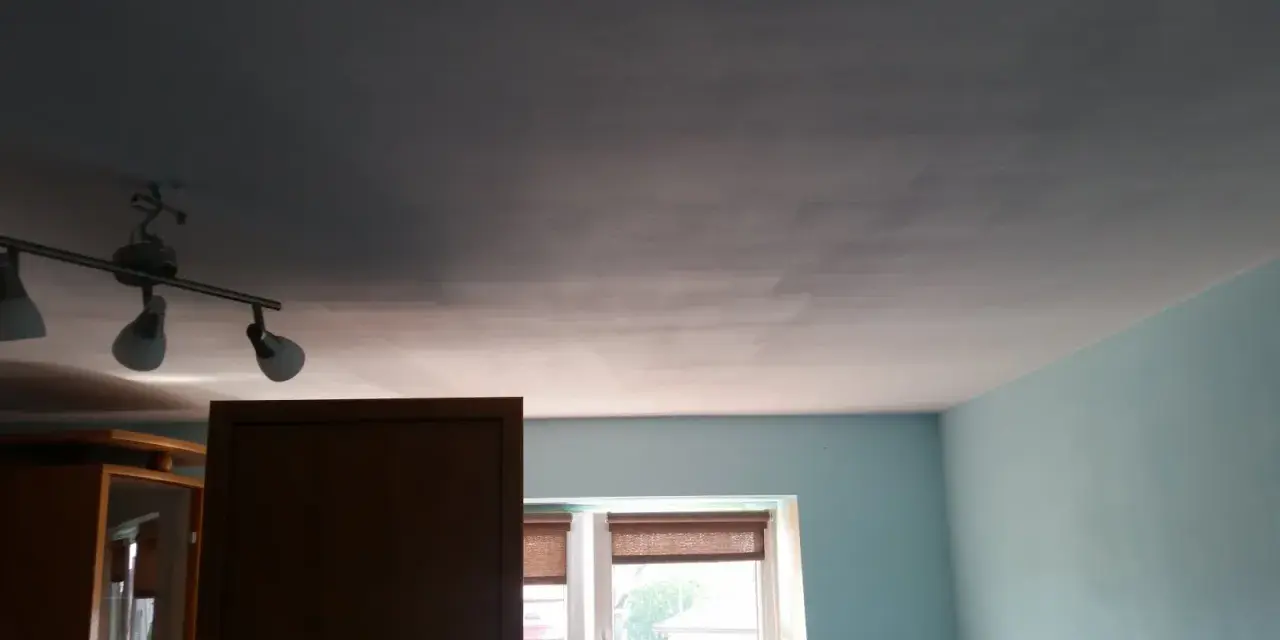 Widoczne smugi na suficie po malowaniu, wynikające z nierównomiernego krycia farby.