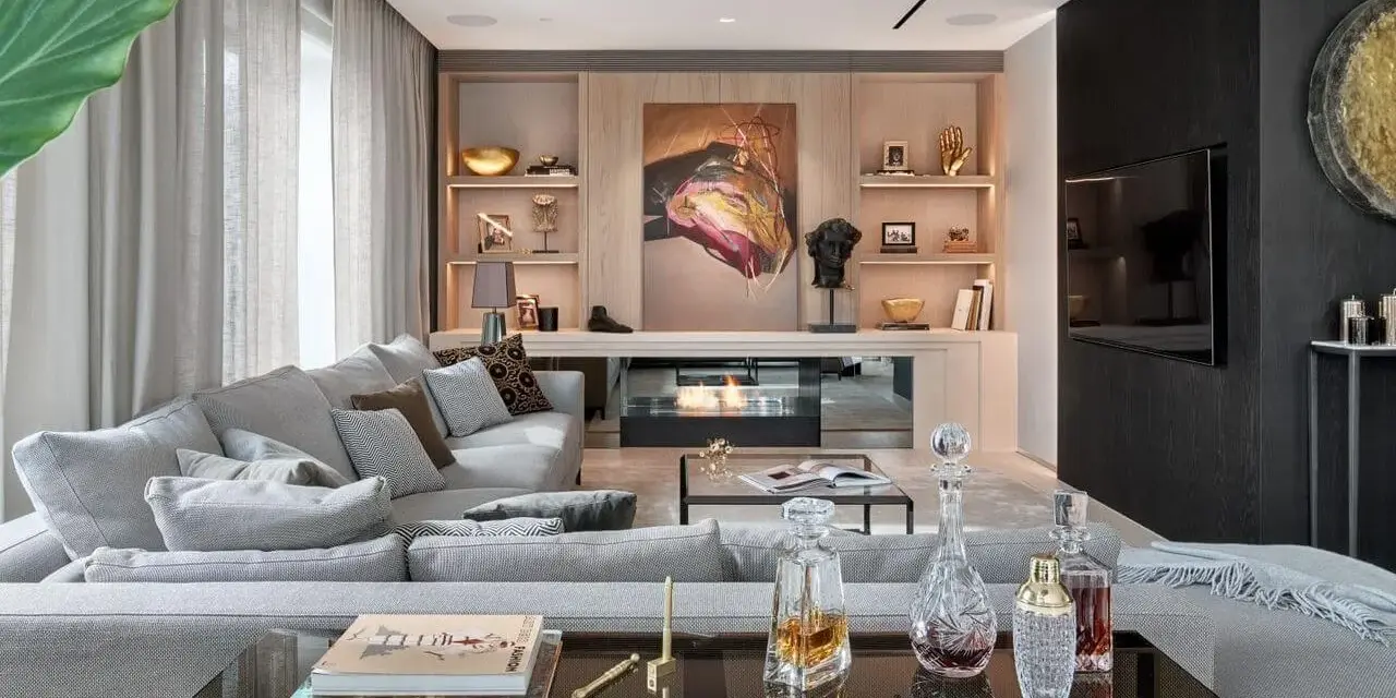 Elegancki salon w stylu nowojorskim z wygodną szarą sofą, nowoczesnym kominkiem i dziełem sztuki.