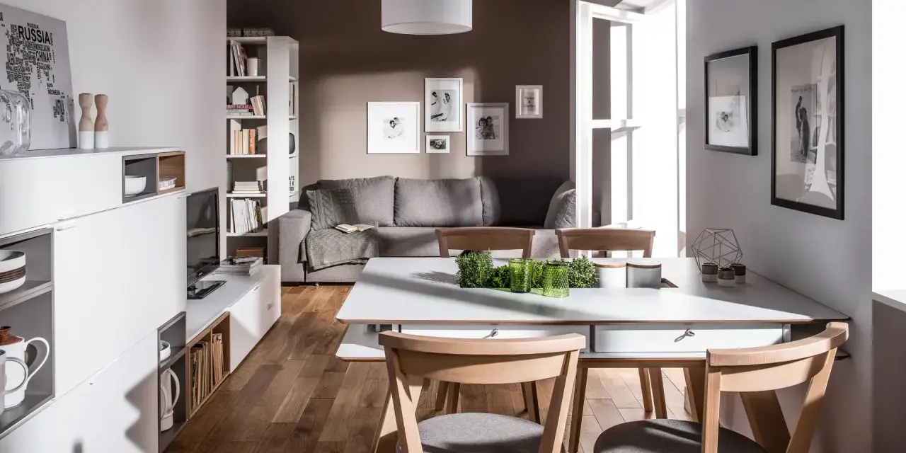Nowoczesny salon z szarą kanapą i brązowymi drewnianymi elementami. Czy kolor szary pasuje do brązu? Tak, tworzy przytulną atmosferę.