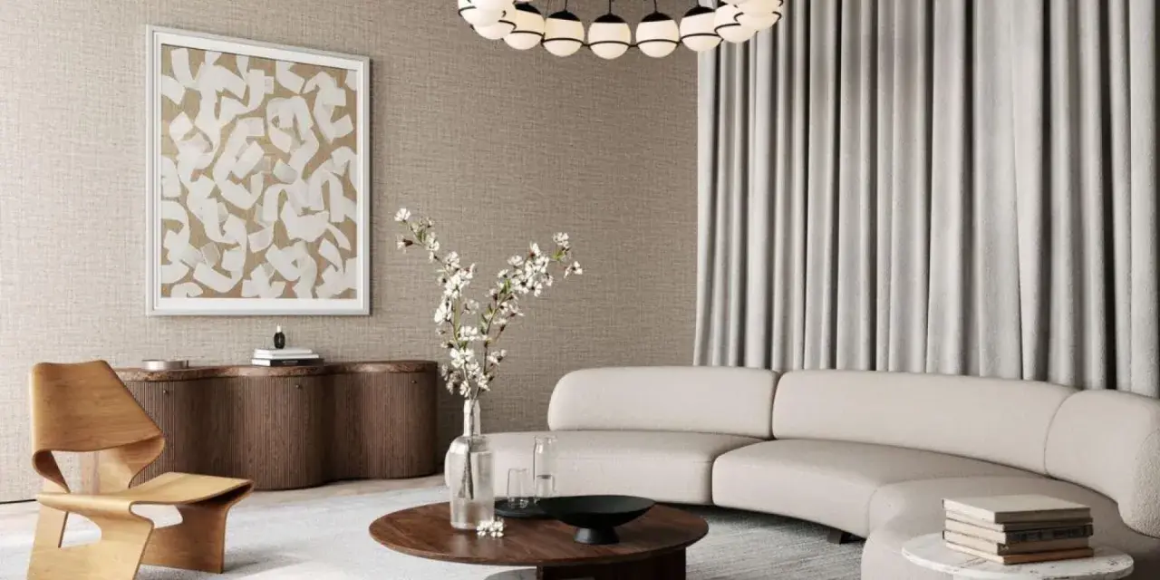 Salon w stylu modern classic z zakrzywioną sofą, drewnianym fotelem i okrągłym stolikiem.