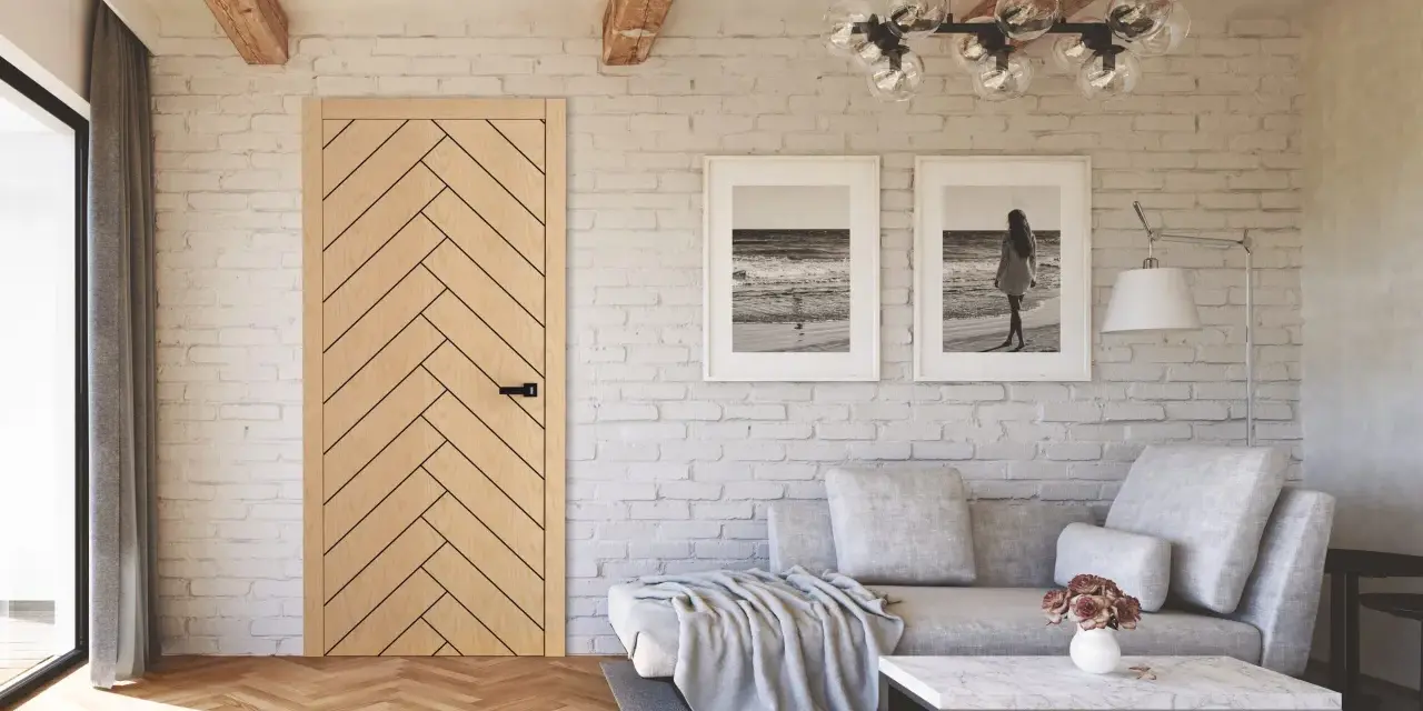 Jasne, oto opis:

Salon w stylu modern farmhouse z drewnianą podłogą w jodełkę, ceglaną ścianą i dwoma obrazami z motywem morza.