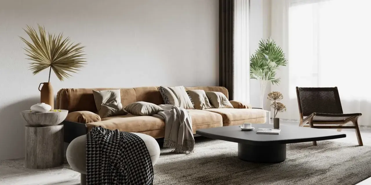 Salon w stylu wabi sabi: brązowa kanapa, kamienny stolik, pleciony fotel i suszone rośliny tworzą przytulną, niedoskonałą przestrzeń.