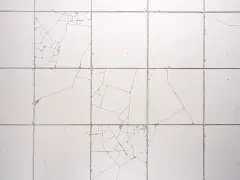 Pęknięte białe płytki na ścianie. Zobacz, jak zamaskować pękniętą płytkę, by odnowić wnętrze.