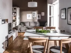Nowoczesny salon z szarą kanapą i brązowymi drewnianymi elementami. Czy kolor szary pasuje do brązu? Tak, tworzy przytulną atmosferę.