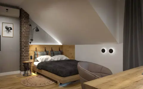 Przytulny pokój na poddaszu z drewnianym łóżkiem i ceglaną ścianą. Inspiracje dla miłośników loftowego stylu.