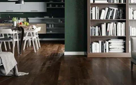 Nowoczesny salon z ciemną podłogą, kuchnią i regałem pełnym książek.