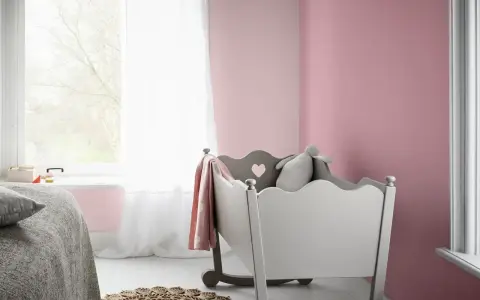 Pokój dziecięcy z łóżeczkiem i kocykiem w odcieniu amarant kolor.