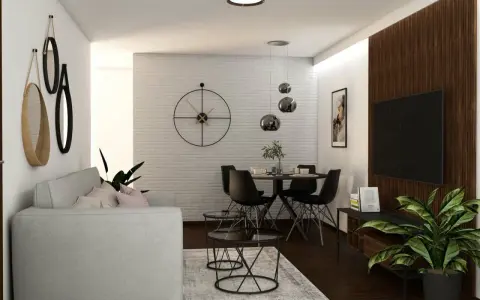 Nowoczesny salon z szarą kanapą, okrągłym stołem i czarnymi krzesłami. W tle biała ceglana ściana z dużym zegarem. Ciemna, brązowa podłoga w salonie dodaje elegancji.