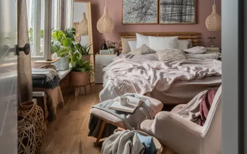 Przytulna sypialnia w stylu boho z dużą ilością roślin, plecionymi lampami i miękkimi tekstyliami.