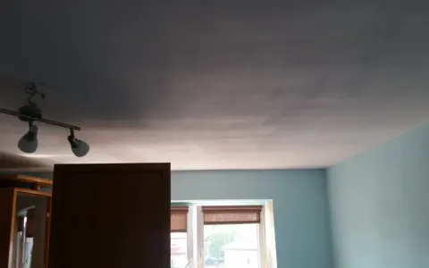 Widoczne smugi na suficie po malowaniu, wynikające z nierównomiernego krycia farby.