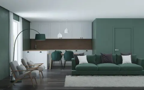 Nowoczesny salon z kuchnią, gdzie dominują zielony kolor ścian i mebli. Wygodna sofa, fotele i stół z krzesłami tworzą przytulną przestrzeń.
