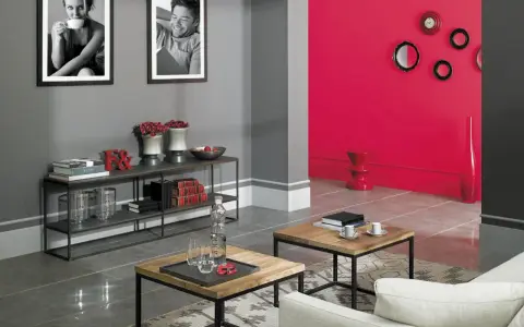 Szare ściany z czym łączyć? Z żywą czerwienią, czernią i bielą. Nowoczesny salon z czarnymi ramkami, stolikami i półkami.