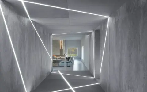 Nowoczesny korytarz z betonowymi ścianami i sufitem, ozdobiony geometrycznym, liniowym podświetleniem. Świetny pomysł na podświetlenie ściany, tworzący futurystyczny efekt.