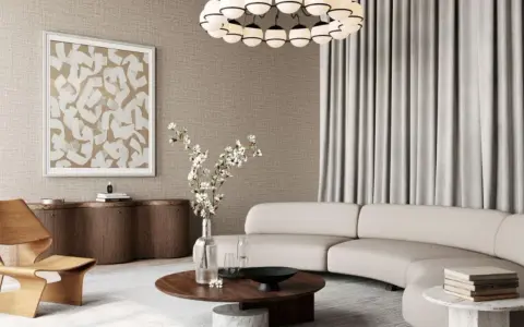 Salon w stylu modern classic z zakrzywioną sofą, drewnianym fotelem i okrągłym stolikiem.