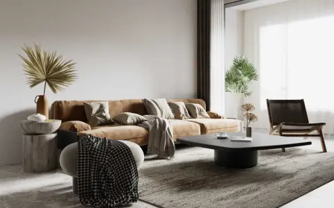 Salon w stylu wabi sabi: brązowa kanapa, kamienny stolik, pleciony fotel i suszone rośliny tworzą przytulną, niedoskonałą przestrzeń.