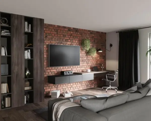 Nowoczesny salon loft inspiracje: ceglana ściana, wisząca szafka RTV, biurko z laptopem, regały i szara kanapa.