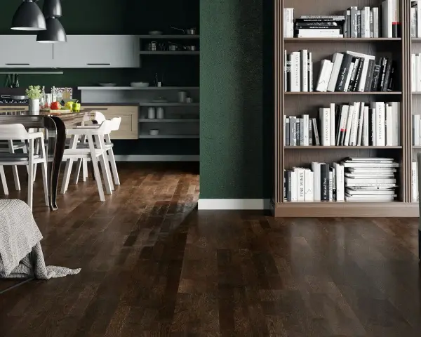 Nowoczesny salon z ciemną podłogą, kuchnią i regałem pełnym książek.