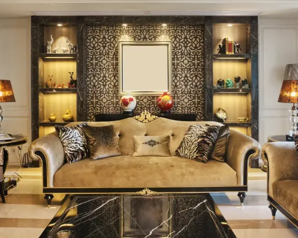 Elegancki salon w stylu art deco z beżową kanapą, ozdobnymi poduszkami i marmurowym stolikiem.