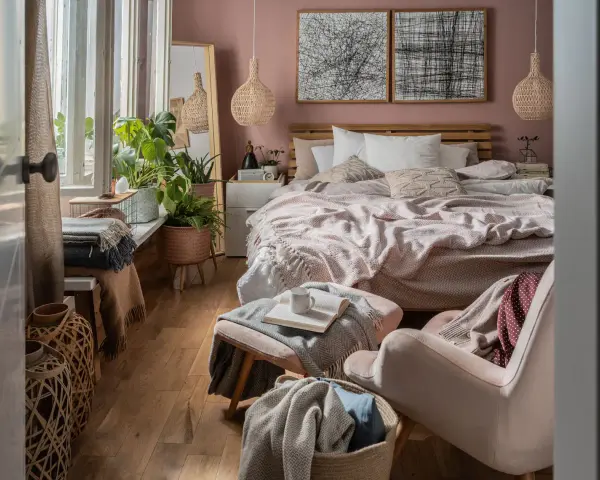 Przytulna sypialnia w stylu boho z dużą ilością roślin, plecionymi lampami i miękkimi tekstyliami.