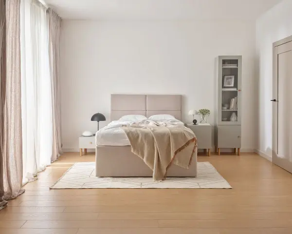 Beżowa sypialnia inspiracje: przytulne łóżko z narzutą, jasne zasłony i minimalistyczne meble tworzą spokojną atmosferę.