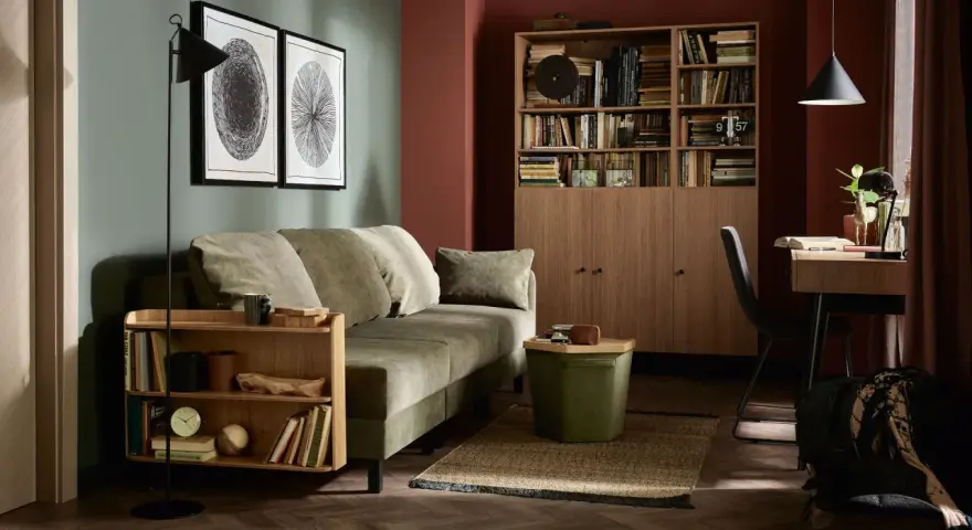 Jak urzadzic pokoj goscinny: przytulna zielona sofa, drewniana biblioteczka i stylowe dodatki tworzą idealne miejsce dla gości.