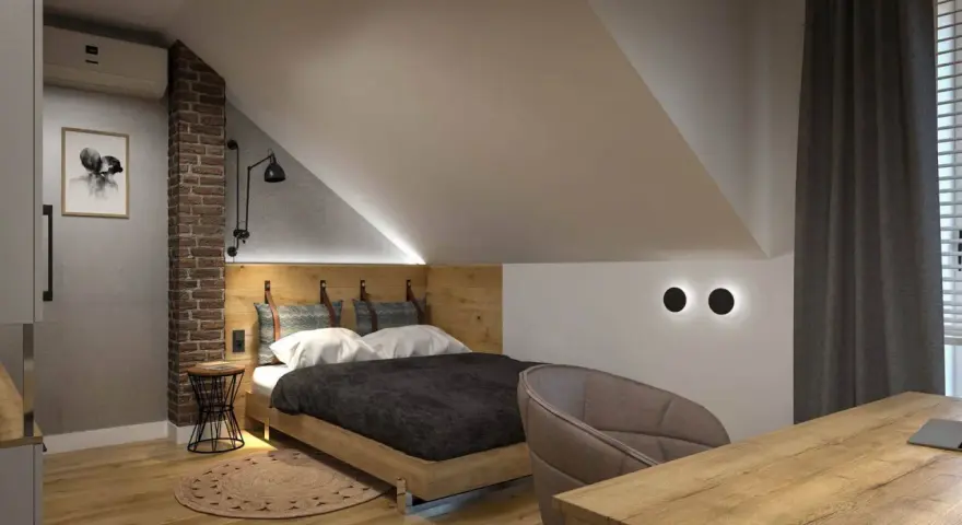 Przytulny pokój na poddaszu z drewnianym łóżkiem i ceglaną ścianą. Inspiracje dla miłośników loftowego stylu.