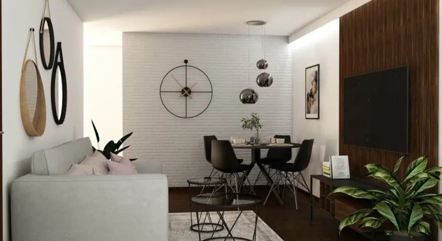 Nowoczesny salon z szarą kanapą, okrągłym stołem i czarnymi krzesłami. W tle biała ceglana ściana z dużym zegarem. Ciemna, brązowa podłoga w salonie dodaje elegancji.