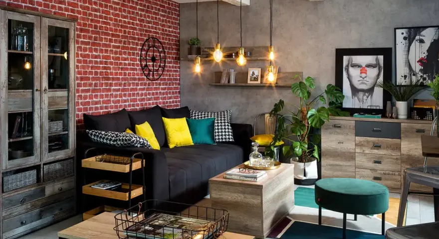 Męski pokój inspiracje: loftowy klimat z ceglaną ścianą, czarną kanapą, drewnianymi meblami i industrialnymi lampami.