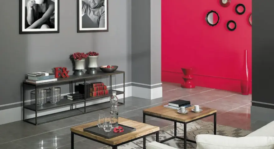 Szare ściany z czym łączyć? Z żywą czerwienią, czernią i bielą. Nowoczesny salon z czarnymi ramkami, stolikami i półkami.