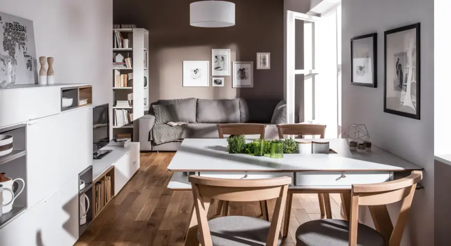 Nowoczesny salon z szarą kanapą i brązowymi drewnianymi elementami. Czy kolor szary pasuje do brązu? Tak, tworzy przytulną atmosferę.