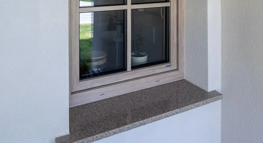 Granitowy parapet zewnętrzny wystaje na ok. 5 cm, zapewniając ochronę i estetykę.