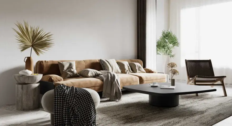Salon w stylu wabi sabi: brązowa kanapa, kamienny stolik, pleciony fotel i suszone rośliny tworzą przytulną, niedoskonałą przestrzeń.