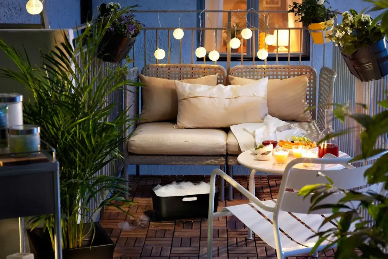 Przytulny balkon z meblami, roślinami i nastrojowymi lampkami. Idealne balkon inspiracje na relaks.
